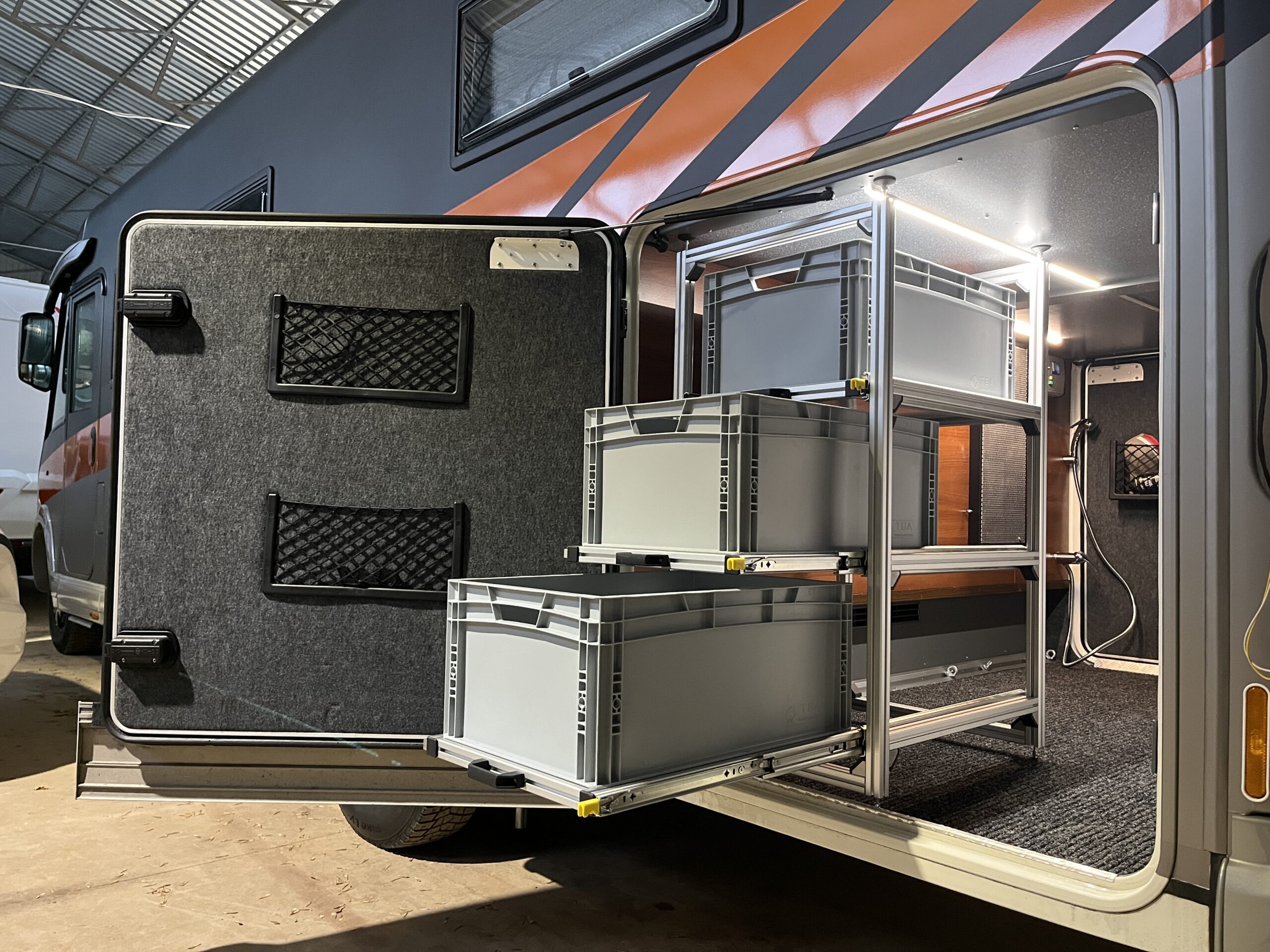 Eritellimusel valmistatud kaubiku riiulisüsteem alumiiniumraamil ja siinidel liikuvate hoiukastidega.